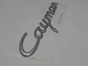 (New) Satin Aluminum Emblem: "Cayman" - 2006-08